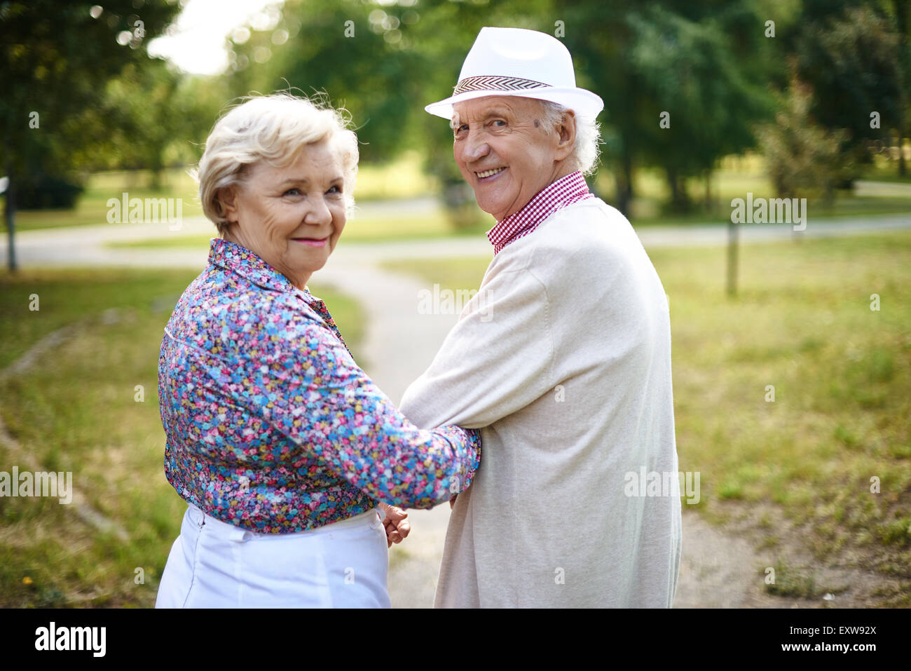 Happy senior couple looking at camera au cours de marche Banque D'Images