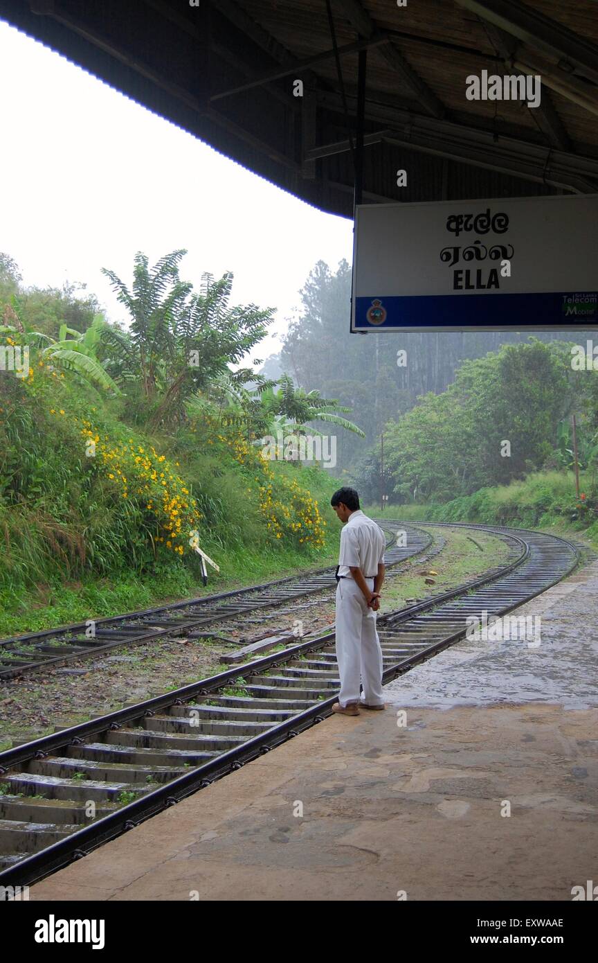 Un homme debout au bord d'une plate-forme sur un jour de pluie à la gare d'Ella, dans la montagne, Sri Lanka Banque D'Images