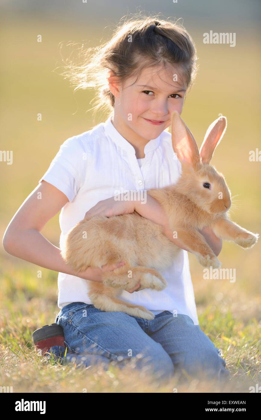 Fille avec son lapin sur pré, Haut-Palatinat, Bavaria, Germany, Europe Banque D'Images