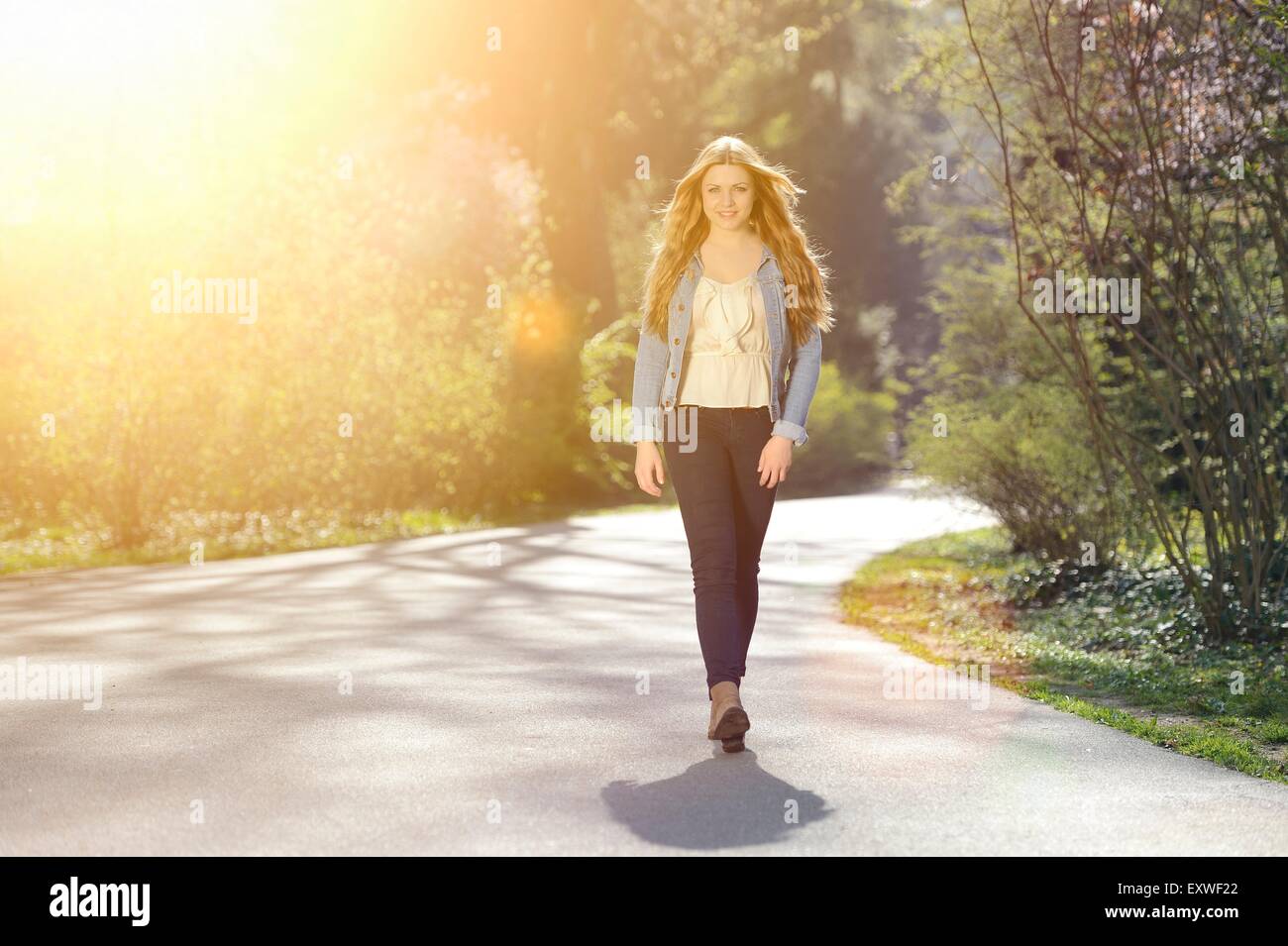 Young woman walking on path in park Banque D'Images