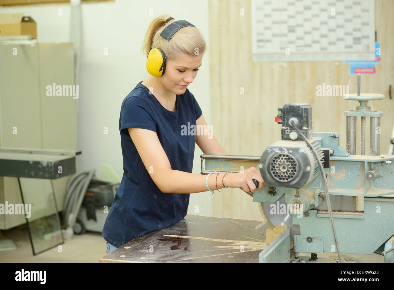 Jeune femme travaillant dans un bois sur un buzzsaw Banque D'Images