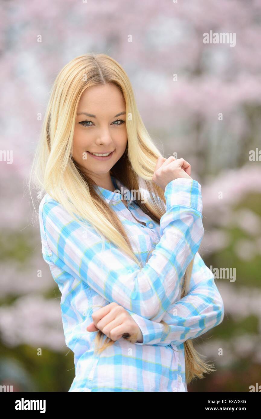 Jeune femme blonde dans un parc au printemps Banque D'Images