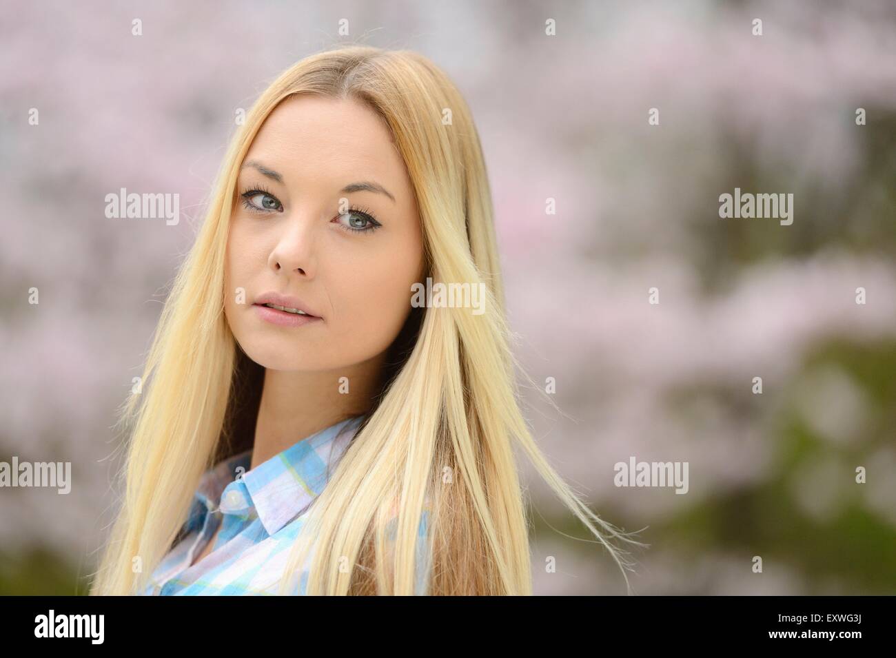 Jeune femme blonde dans un parc au printemps Banque D'Images