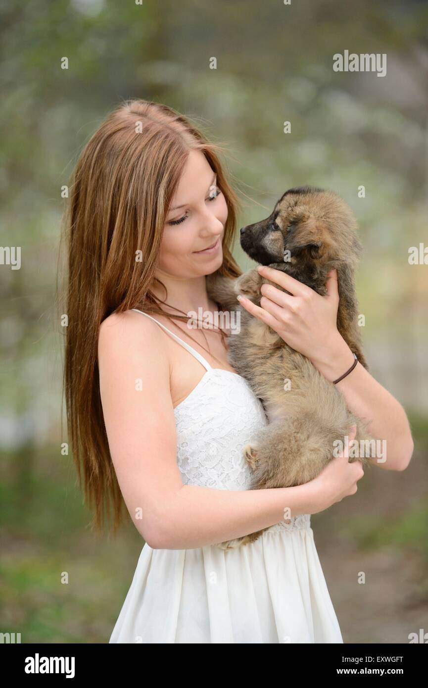 Jeune femme avec un dog puppy in garden Banque D'Images