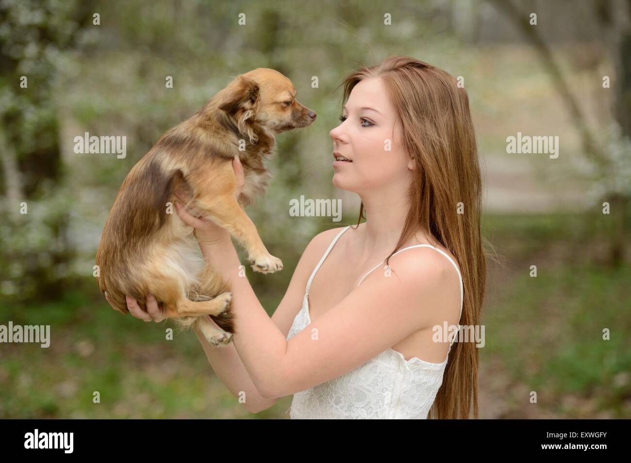 Jeune femme avec un dog puppy in garden Banque D'Images