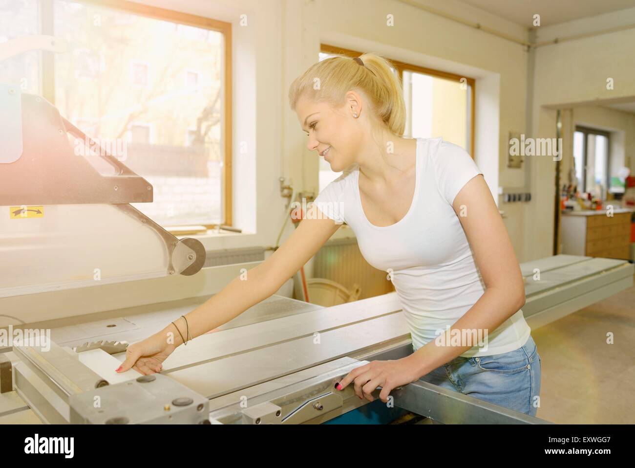 Jeune femme travaillant dans un bois sur un buzzsaw Banque D'Images