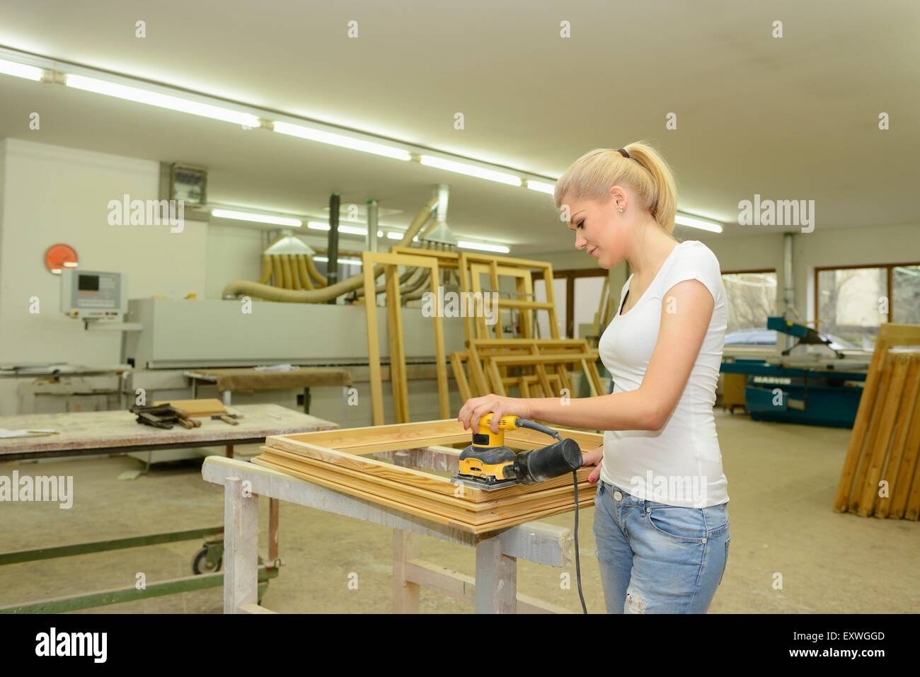 Jeune femme dans un travail de menuiserie sur un cadre de fenêtre Banque D'Images