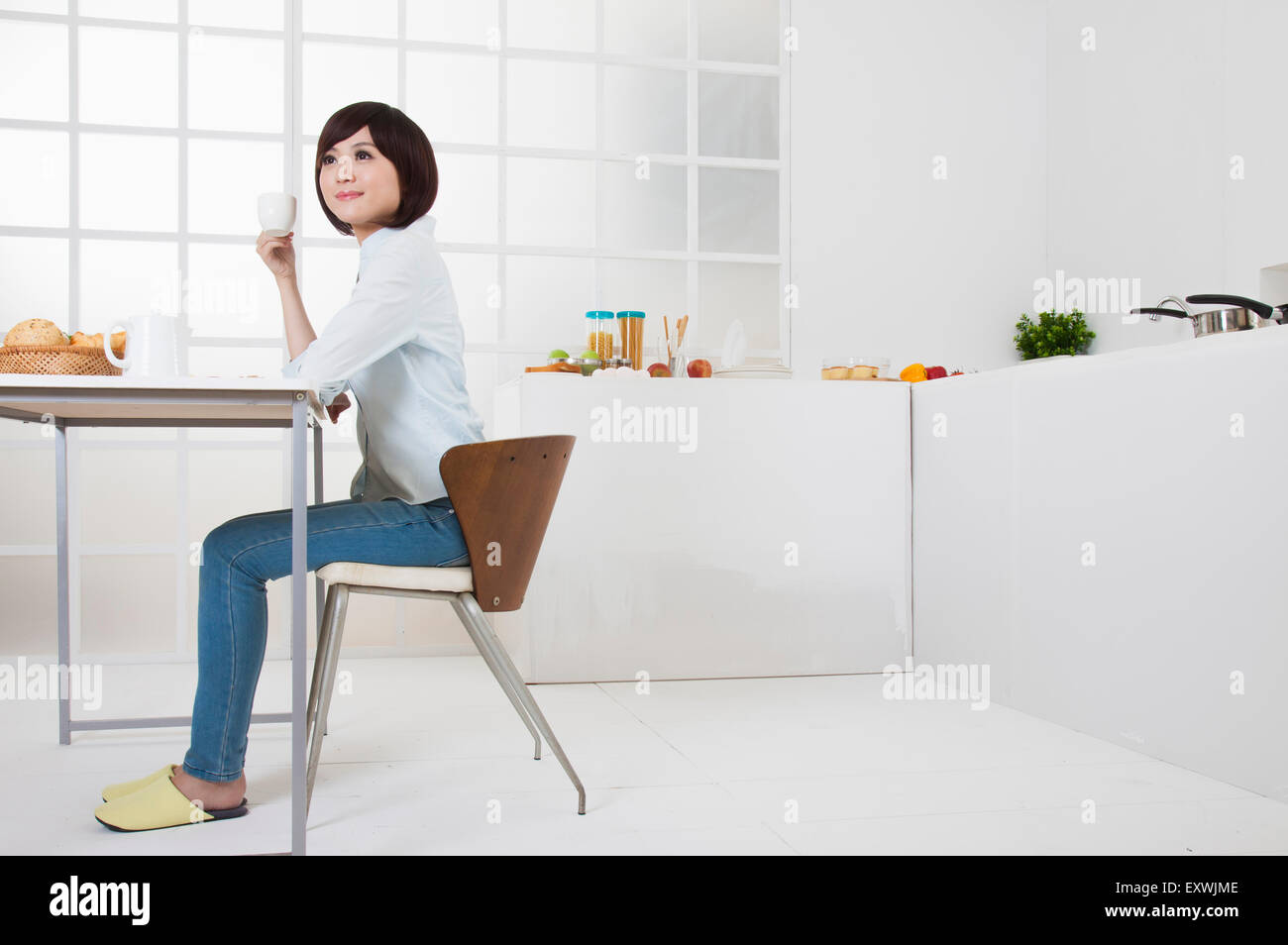 Jeune femme assise et à l'écart avec sourire, Banque D'Images