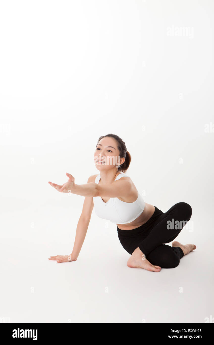 Woman practicing yoga et atteindre une part, Banque D'Images