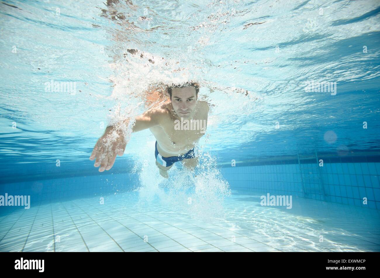 L'homme nage sous l'eau dans une baignoire en plein air Banque D'Images