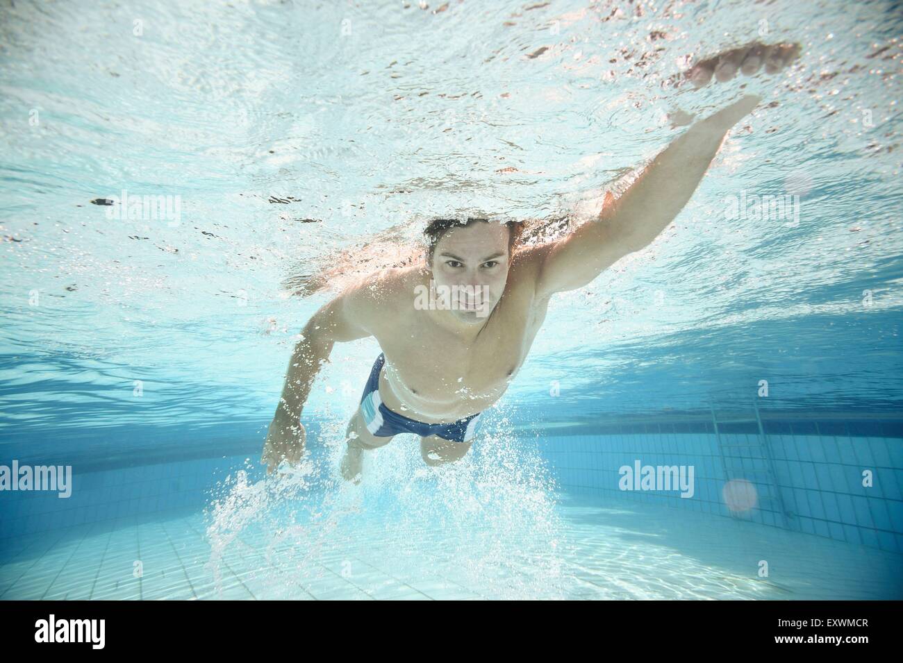 L'homme nage sous l'eau dans une baignoire en plein air Banque D'Images