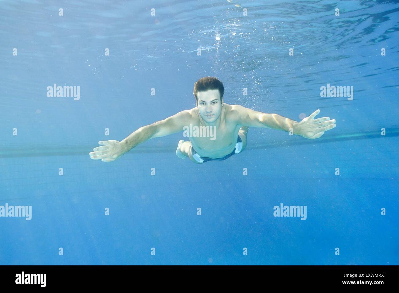 L'homme nage sous l'eau dans une baignoire en plein air Banque D'Images