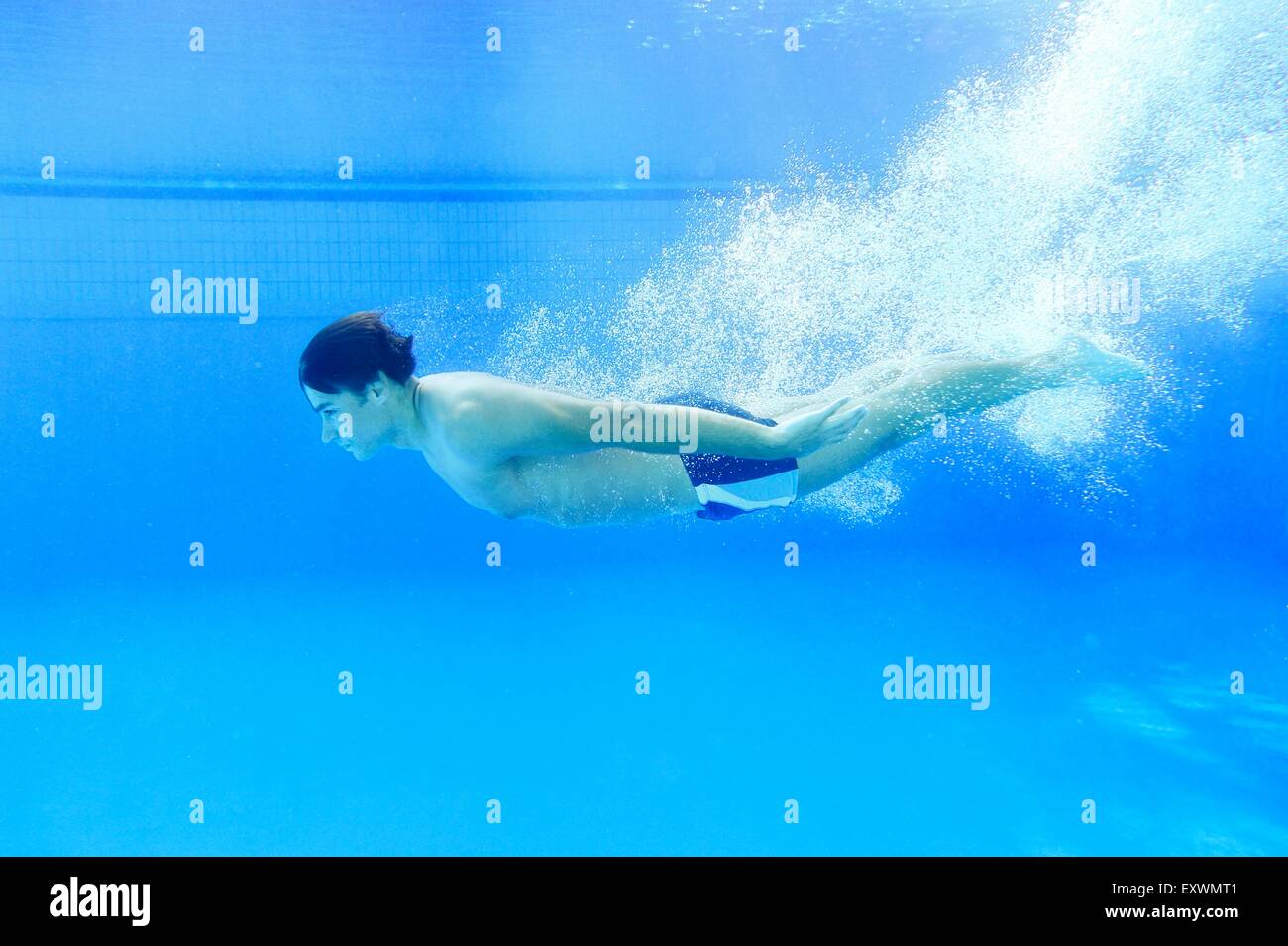 L'homme nage sous l'eau dans une baignoire en plein air Banque D'Images