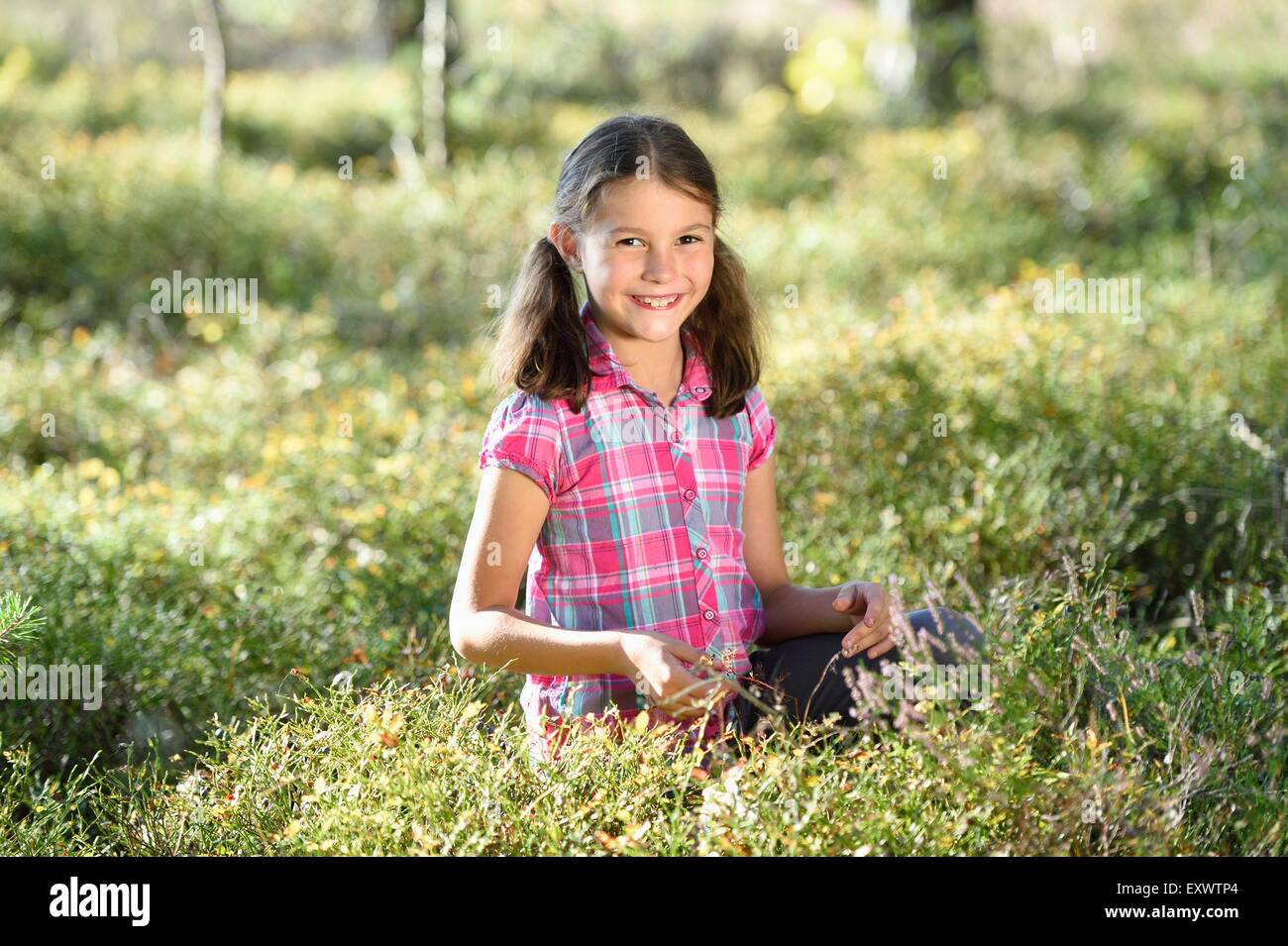 Girl eating berries dans une forêt de pins Banque D'Images