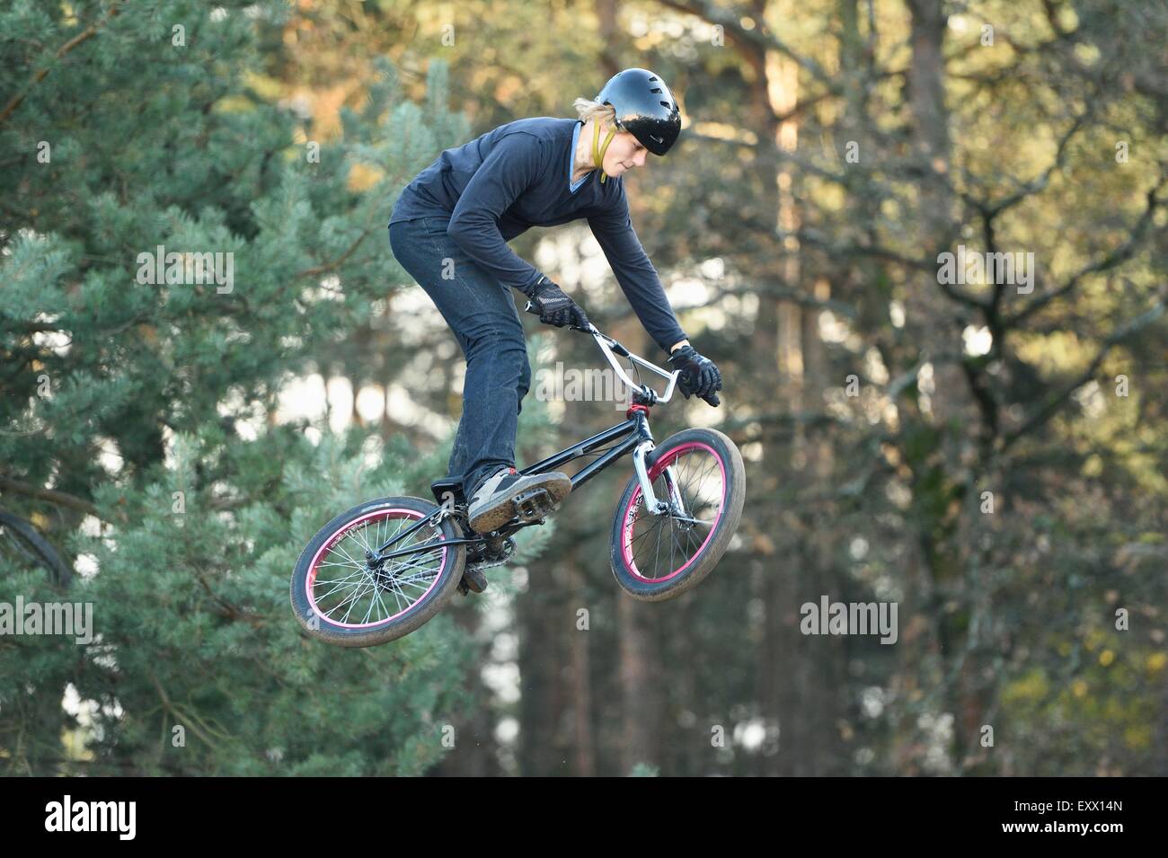 Adolescent qui saute dans l'air avec son vélo BMX Banque D'Images