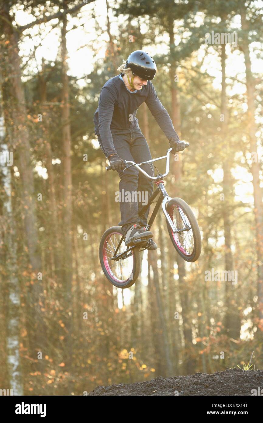 Adolescent qui saute dans l'air avec son vélo BMX Banque D'Images