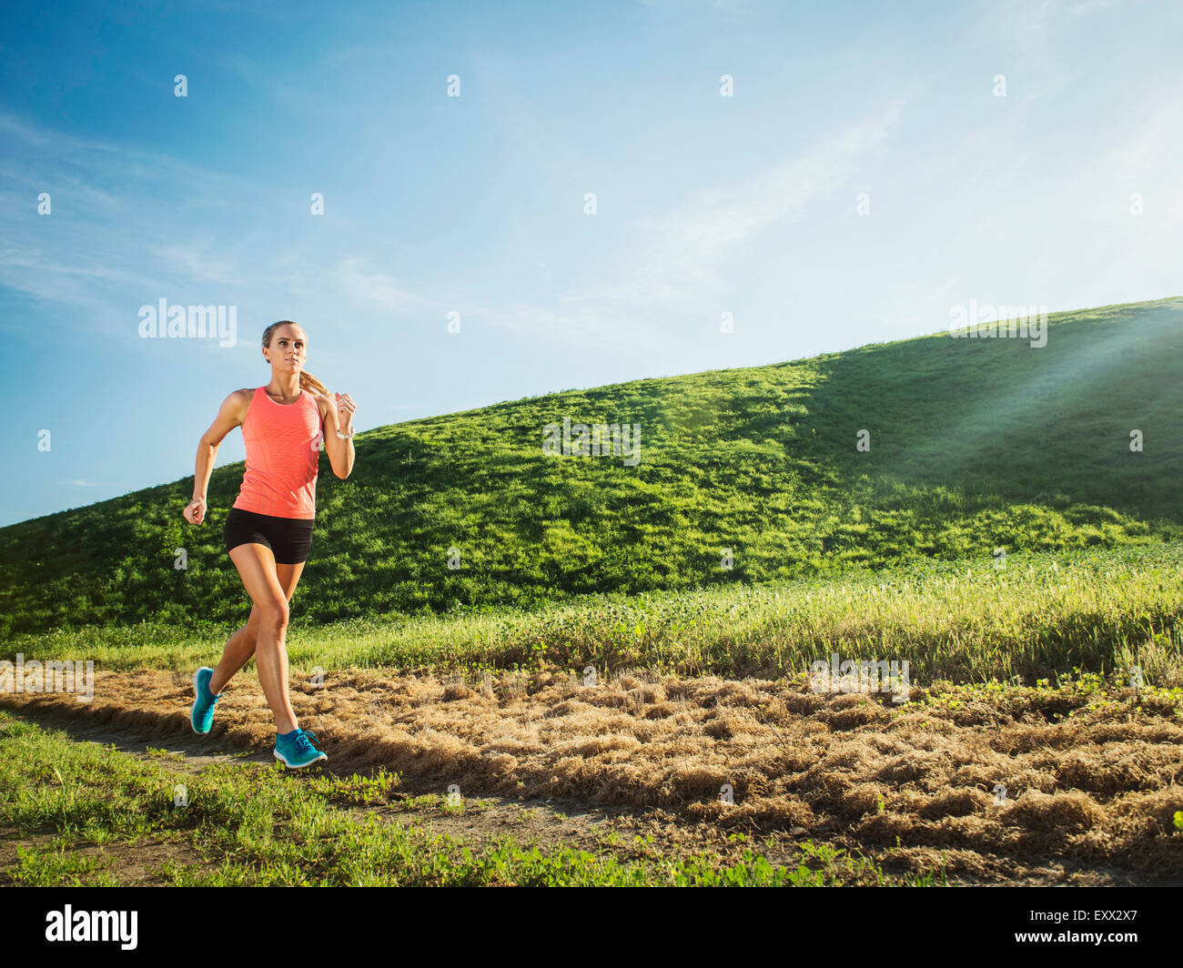 Woman running in field Banque D'Images