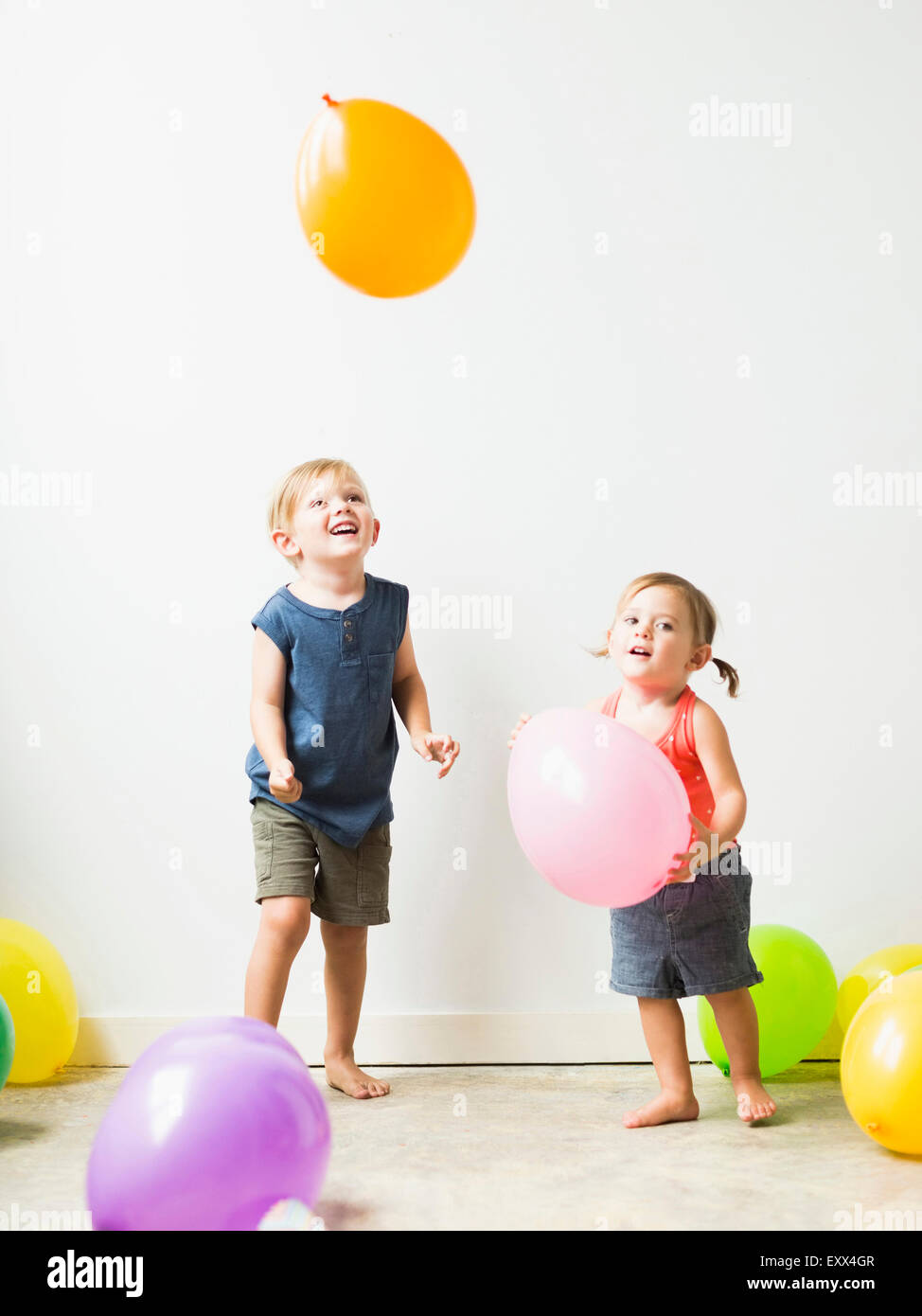 Enfants (2-3) en jouant avec des ballons Banque D'Images