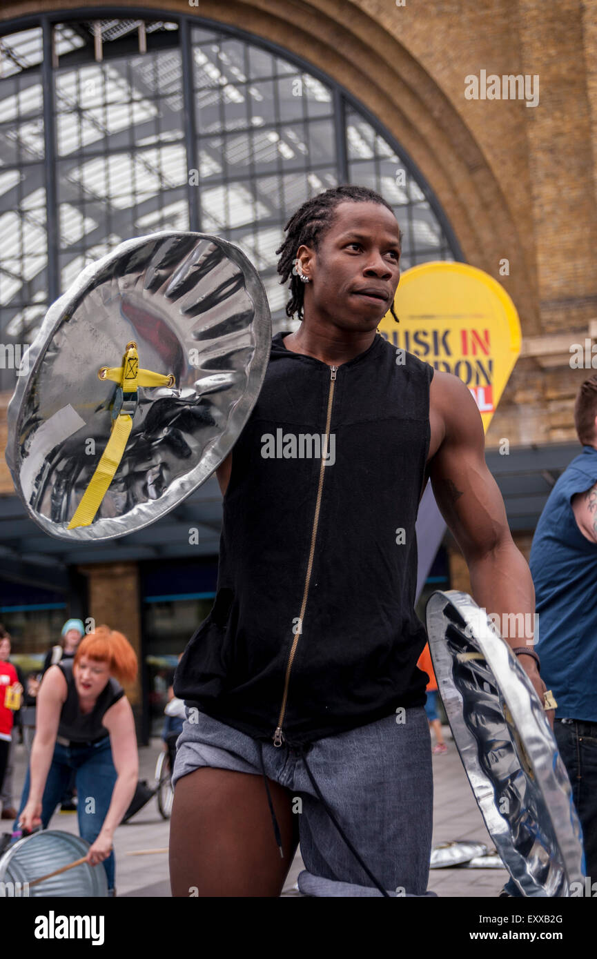 Londres, Royaume-Uni. 17 juillet 2015. Les membres du groupe de percussion, Stomp, de divertir les navetteurs de l'heure de pointe à l'extérieur de King's Cross St Pancras station, car ils aident à lancer des arts de la journée et le Festival à Londres Busk. Crédit : Stephen Chung/Alamy Live News Banque D'Images