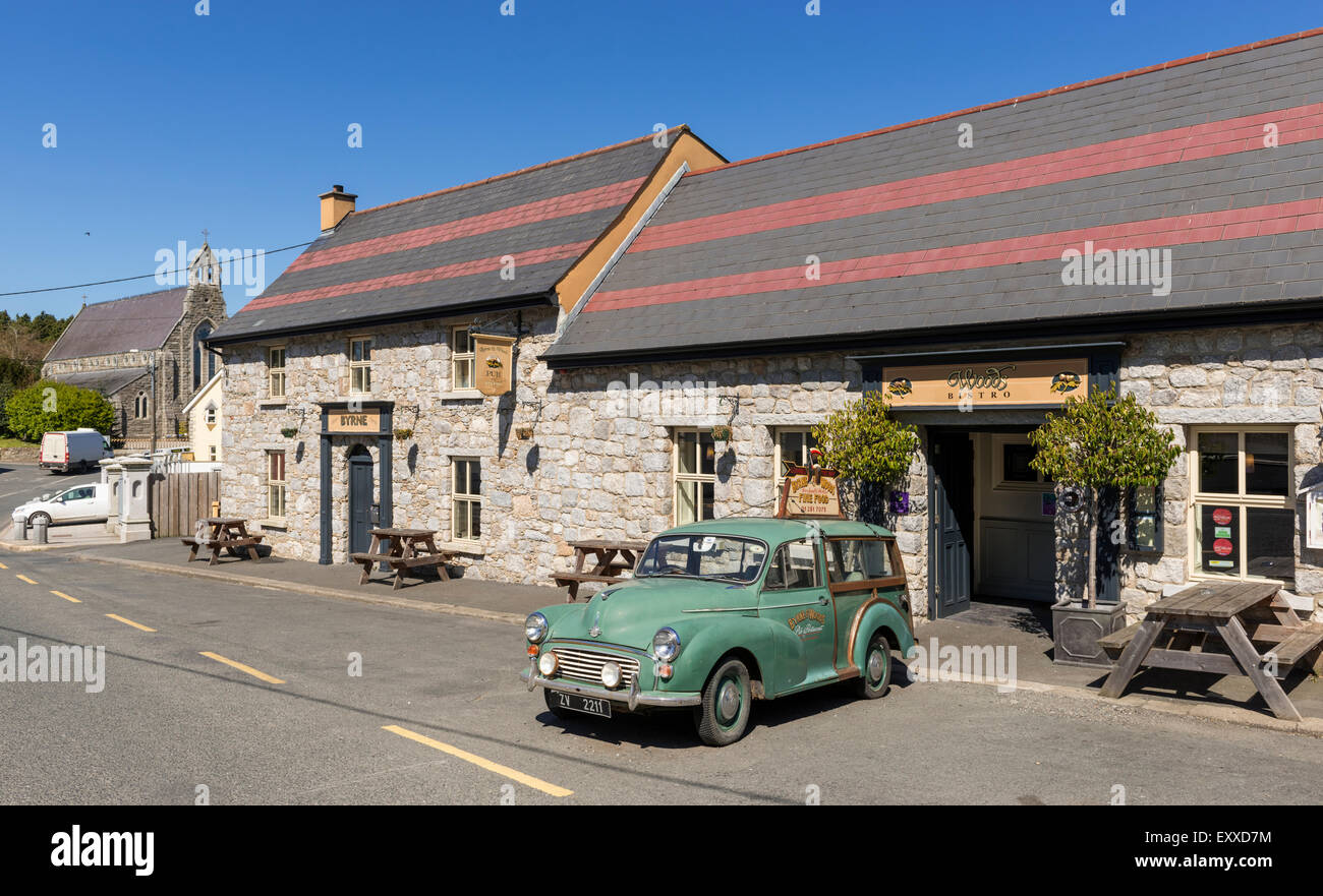 Bar pub irlandais traditionnel dans le village de bois rond, comté de Wicklow, République d'Irlande, avec une vieille voiture garée à l'extérieur Banque D'Images
