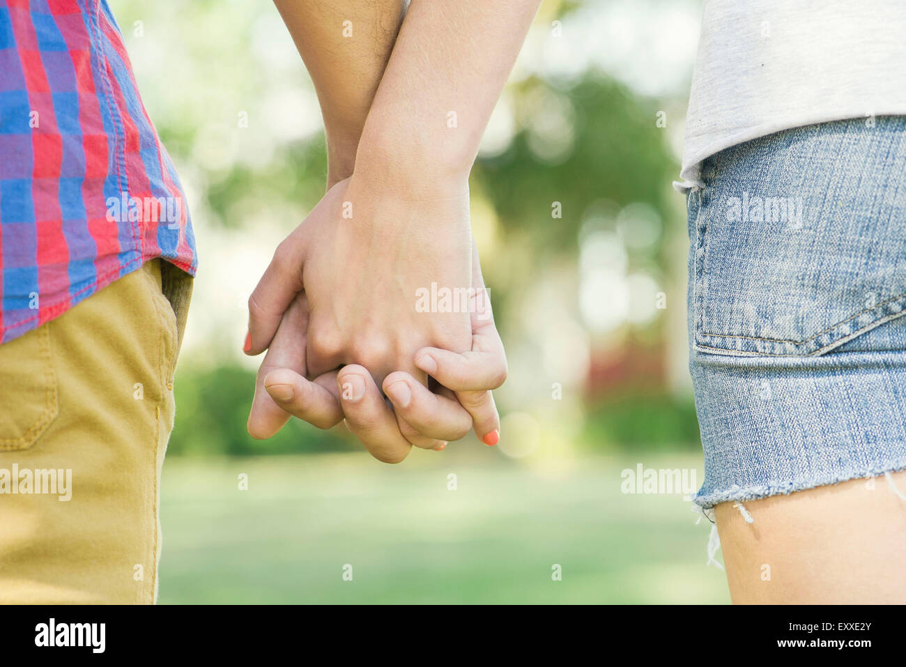 Couple holding hands outdoors, cropped vue arrière Banque D'Images