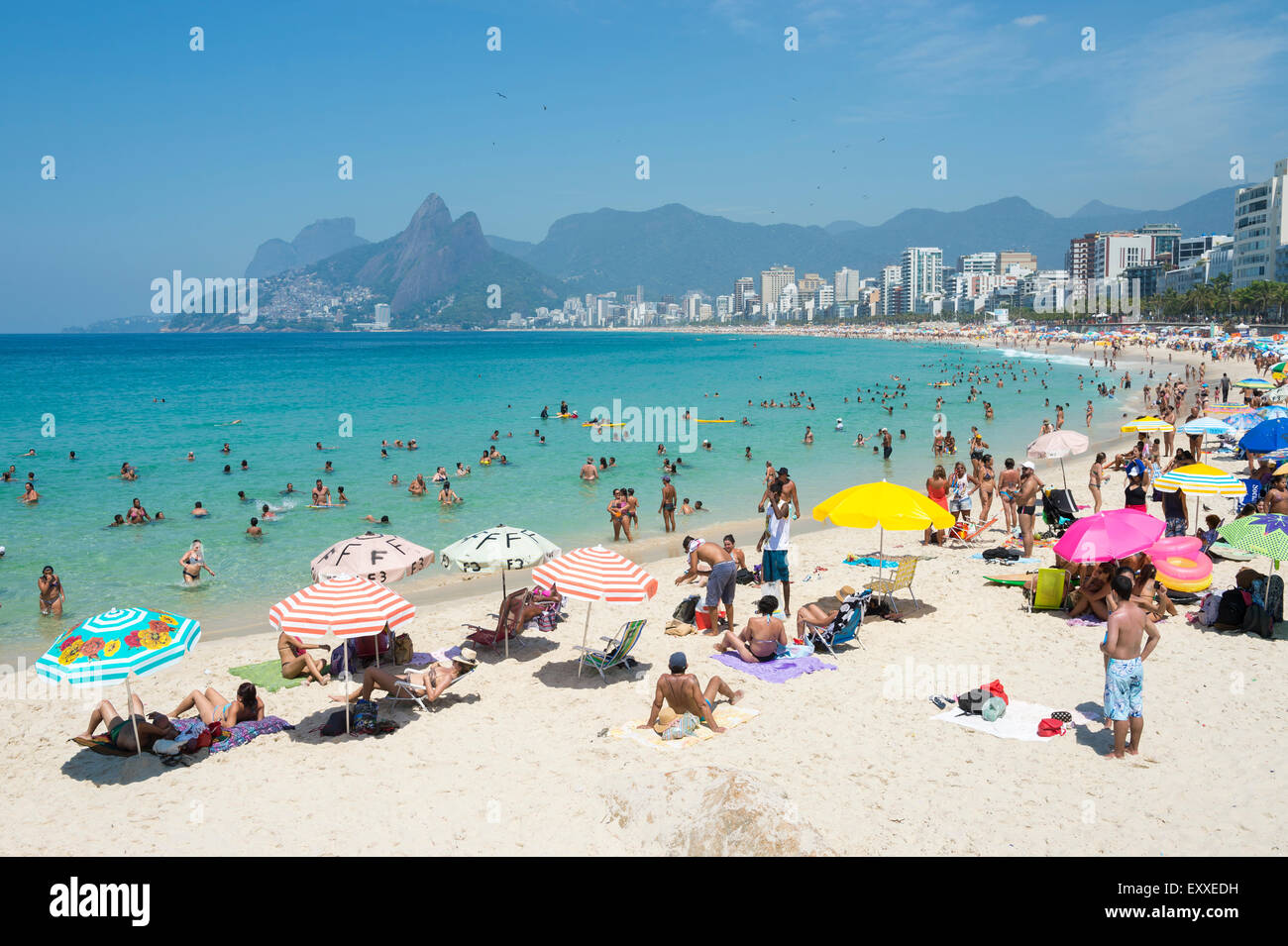 RIO DE JANEIRO, Brésil - février 08, 2015 : Amateurs de vous détendre sur la plage d'Ipanema avec parasols colorés contre la ville. Banque D'Images