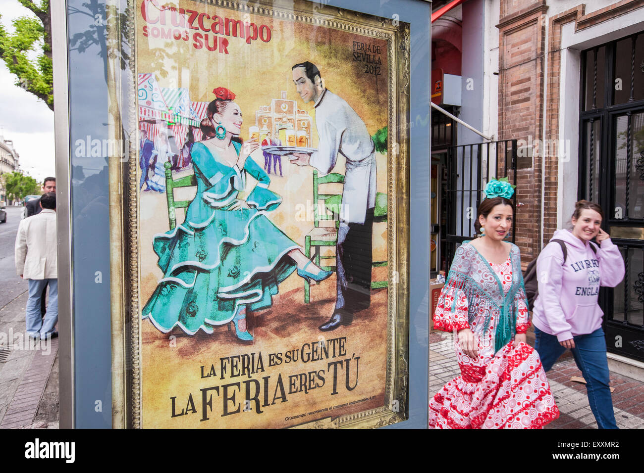 Femme en robe traditionnel de Séville en passant pour l'affiche de la Feria d'avril Festival au centre de Séville, Andalousie, Espagne, Europe. Banque D'Images