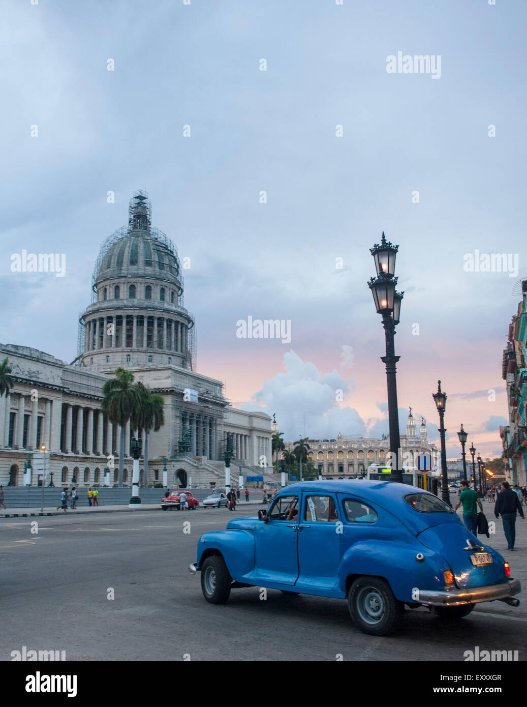 Un bleu vintage voiture conduit le long au crépuscule dans de le capitol à La Havane, Cuba Banque D'Images