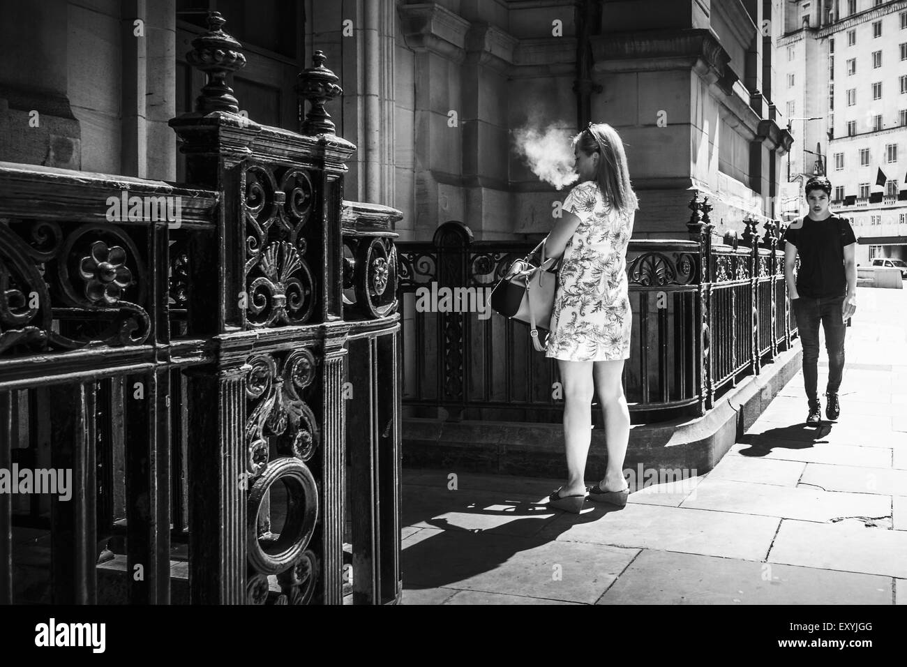 UK : style de femme personne fumer une cigarette à l'extérieur d'un immeuble de bureaux, Leeds Banque D'Images