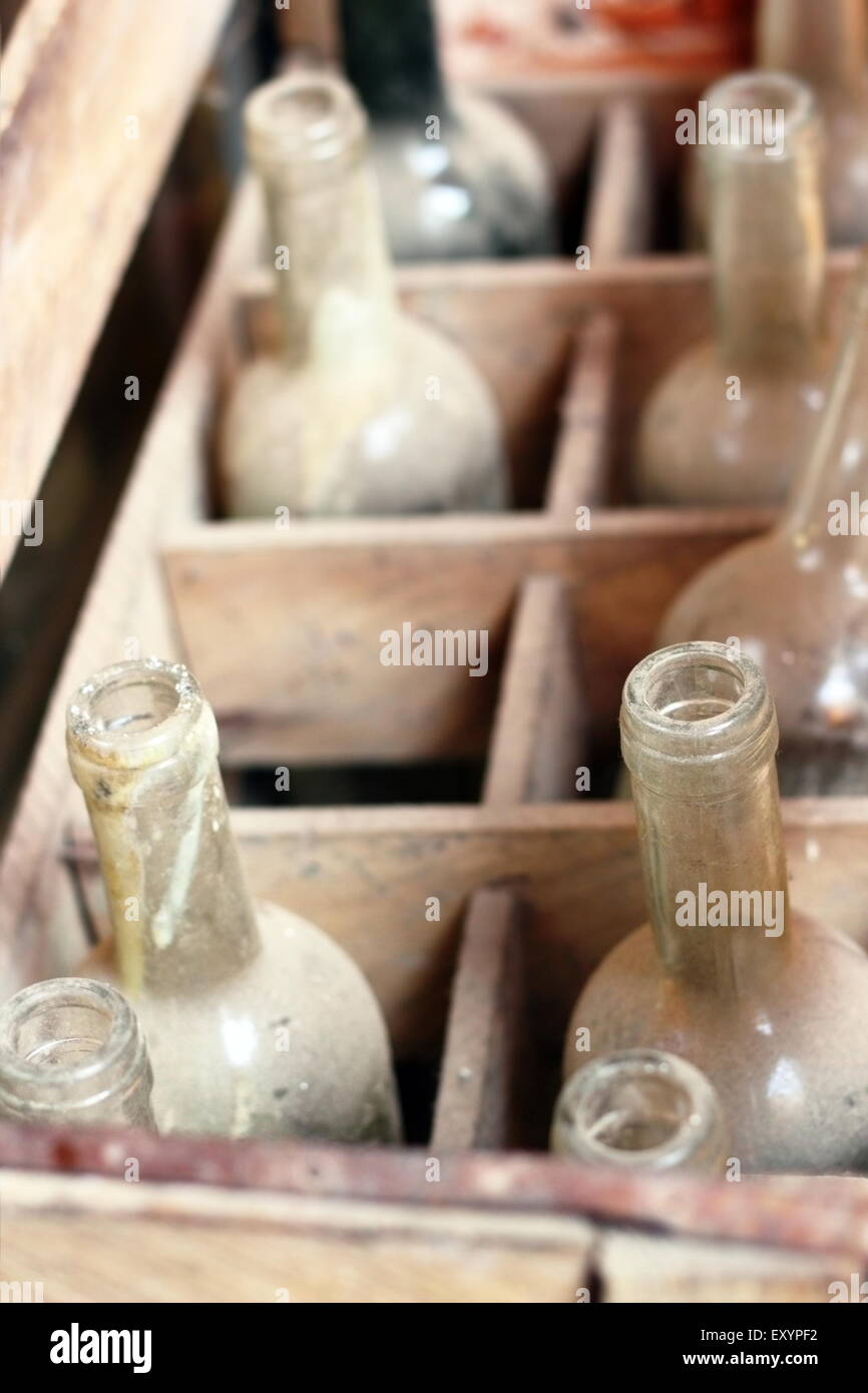 Vieilles bouteilles de vin vides dans une boîte en bois Banque D'Images