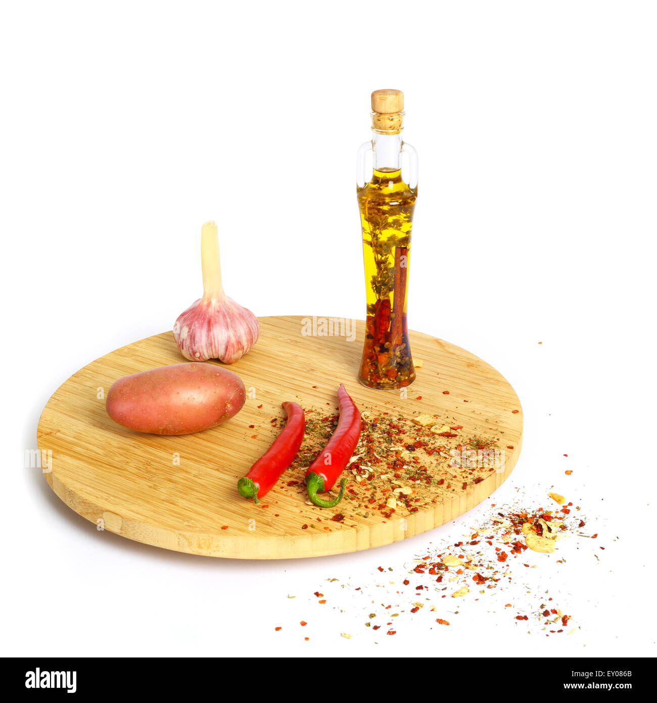 Épices et une bouteille d'huile de cuisson sur plank isolé sur fond blanc Banque D'Images
