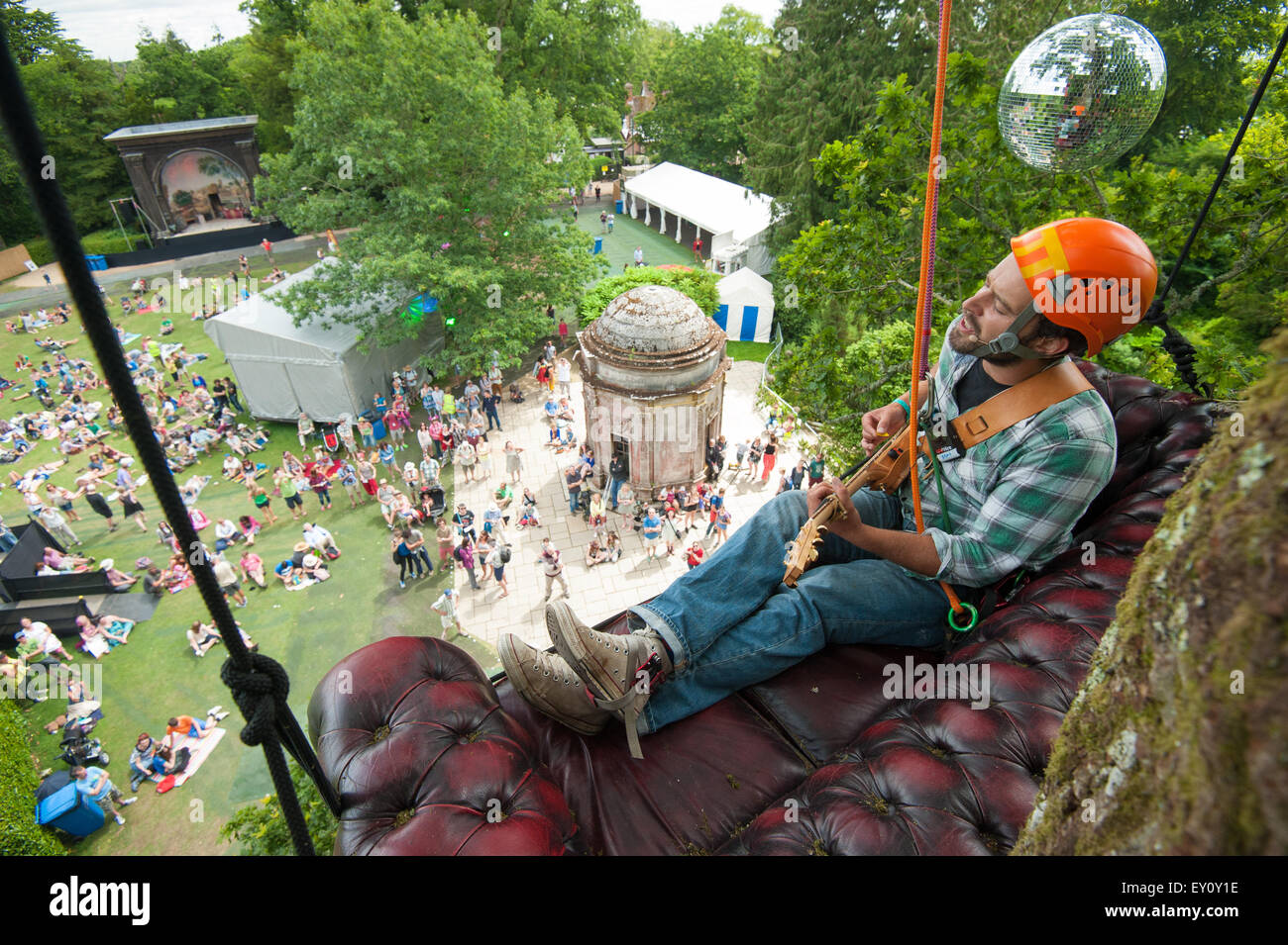 Larmer Tree Gardens, Wiltshire, Royaume-Uni. 19 juillet 2015. Ben Trevor, l'arbre haut Troubadour, effectue depuis le haut d'un chêne dans Larmer Tree Gardens, Wiltshire. Il a commencé l'exécution de chansons du haut des arbres pour récolter des fonds pour l'hôpital Royal Marsden qui traités avec succès sa maman. Le festival, qui en est à sa 25e année, en vedette Tom Jones et Femi Kuti comme actes global. Photo : Andrew Walmsley/Alamy Live News Banque D'Images