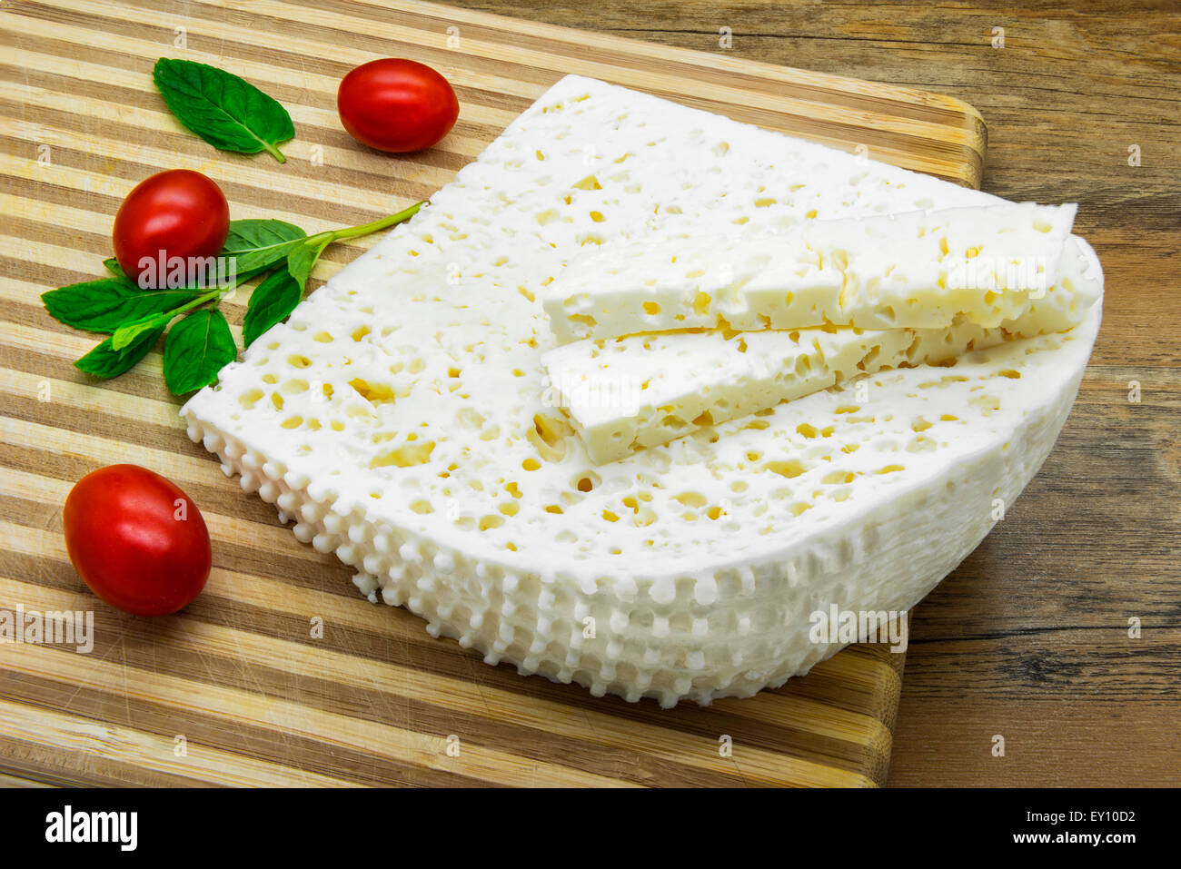 Morceau de fromage blanc, de tomates cerises et de feuilles de mélisse Banque D'Images