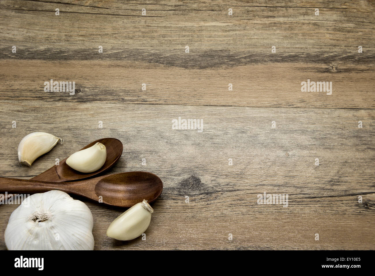 L'ail et des cuillères en bois. Composition rustique. Banque D'Images