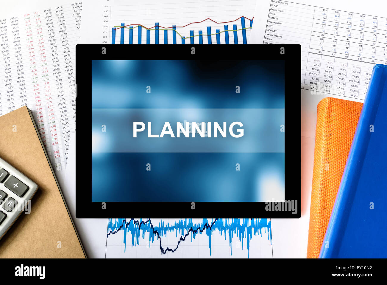 Mot de planification sur tablette avec arrière-plan graphique financier Banque D'Images