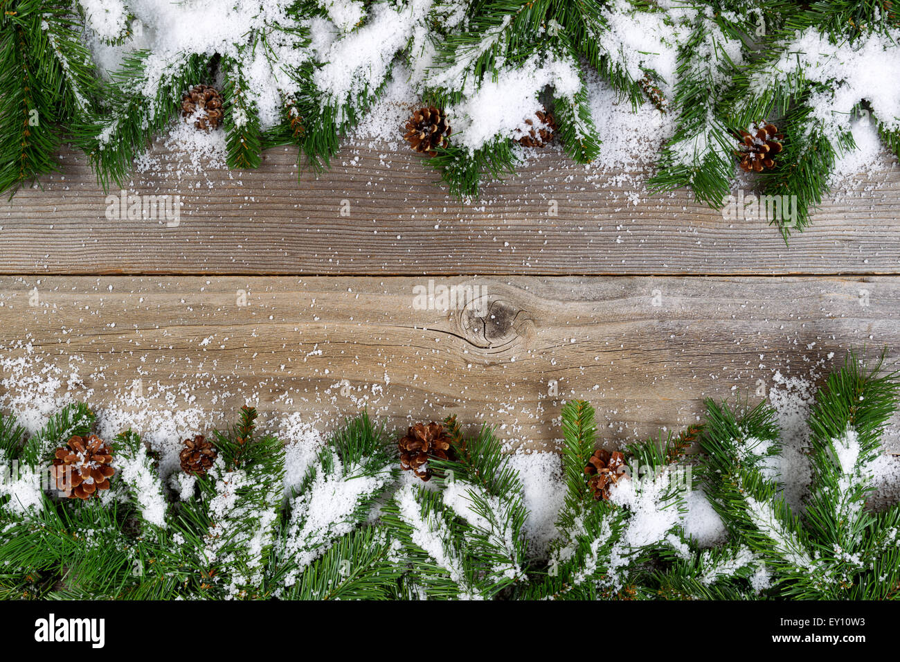 Christmas border, haut et bas du châssis, avec des branches d'arbre de pin, de cônes et de neige sur les planches de bois rustique. La mise en page à l'horizontale Banque D'Images