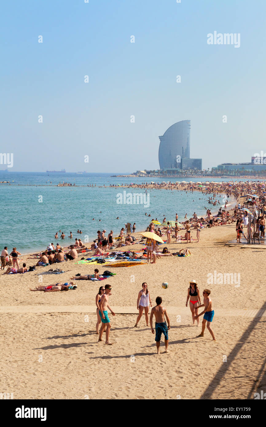 Les gens jouant sur Platya de la Barceloneta Barceloneta Beach ( ), l'hôtel W dans la distance, Barcelone Espagne Europe Banque D'Images