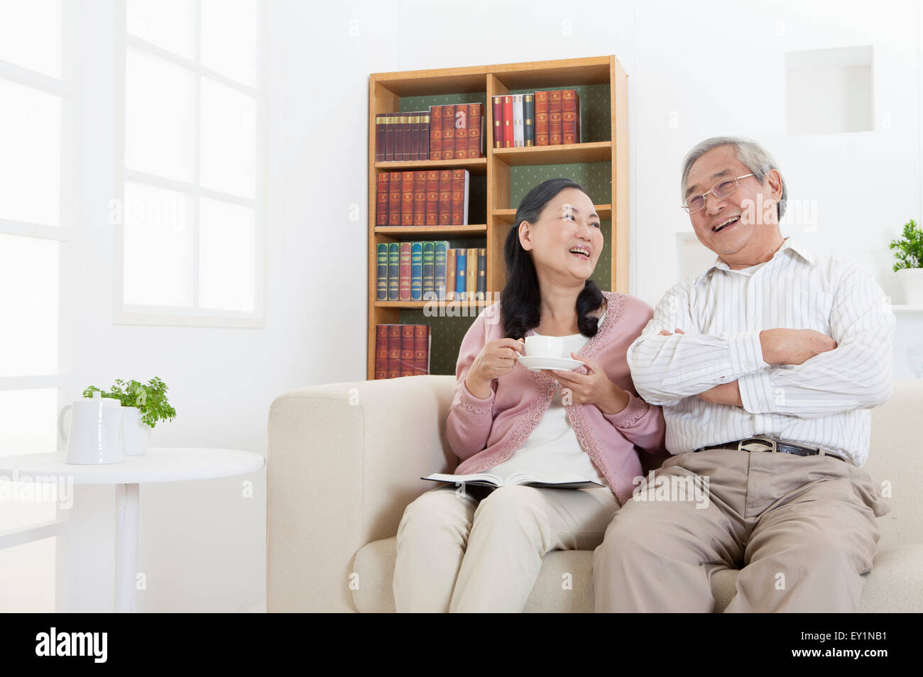 Senior couple sitting on sofa et heureusement, smiling Banque D'Images