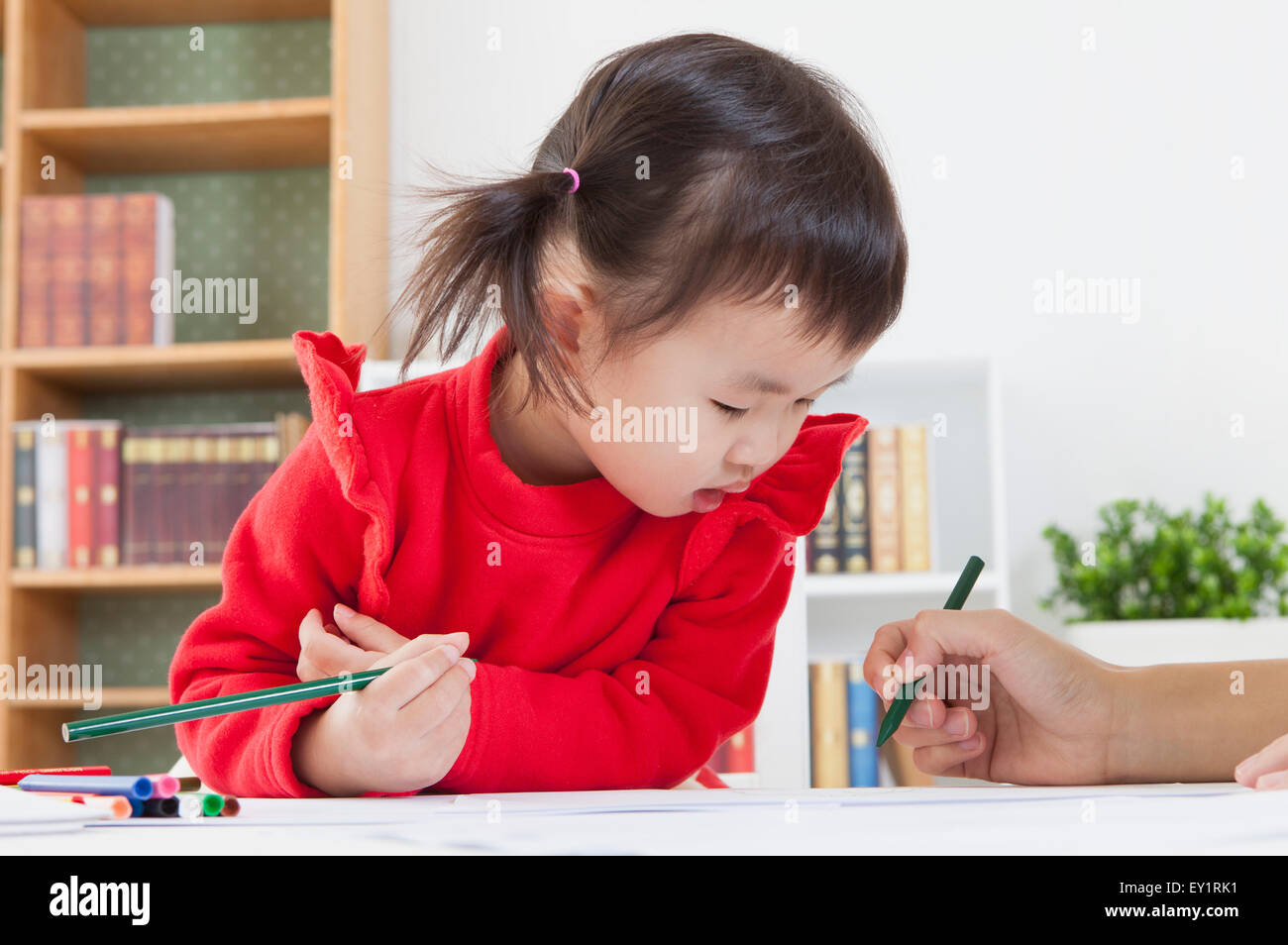Little girl holding crayon de couleur et à la baisse, Banque D'Images