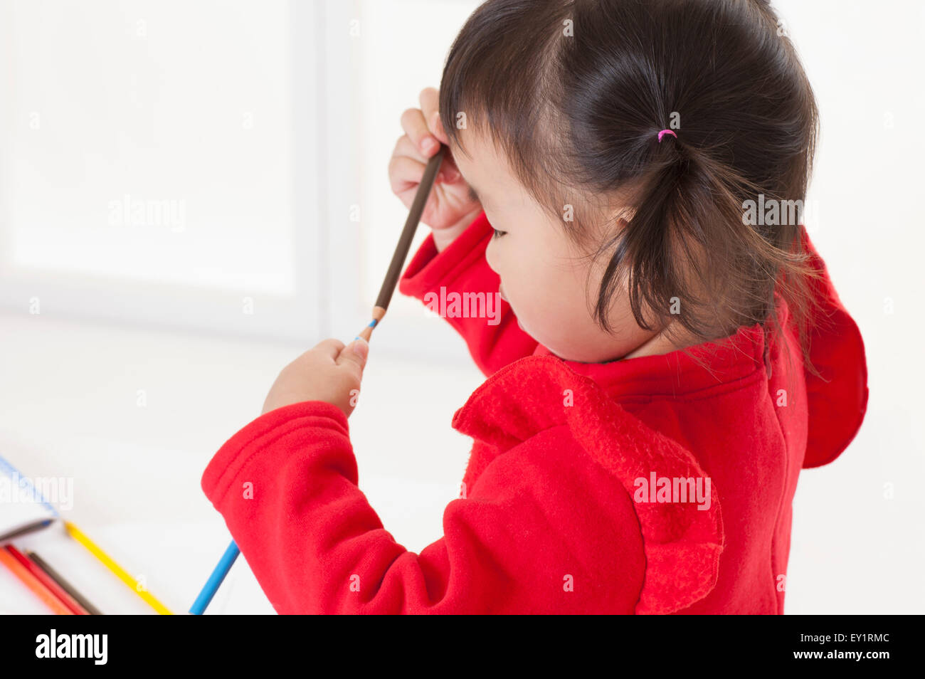 Little girl holding crayon de couleur et à la baisse, Banque D'Images