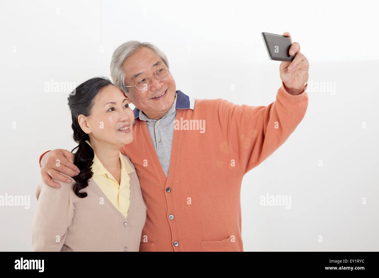 A Senior couple le téléphone mobile et heureusement, smiling Banque D'Images
