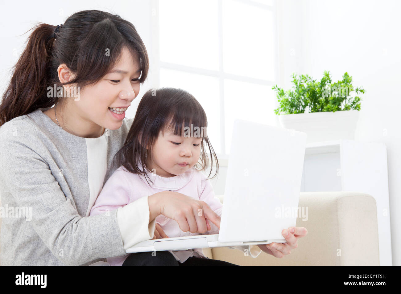 Mère et bébé fille jouant ensemble ordinateur portable, Banque D'Images
