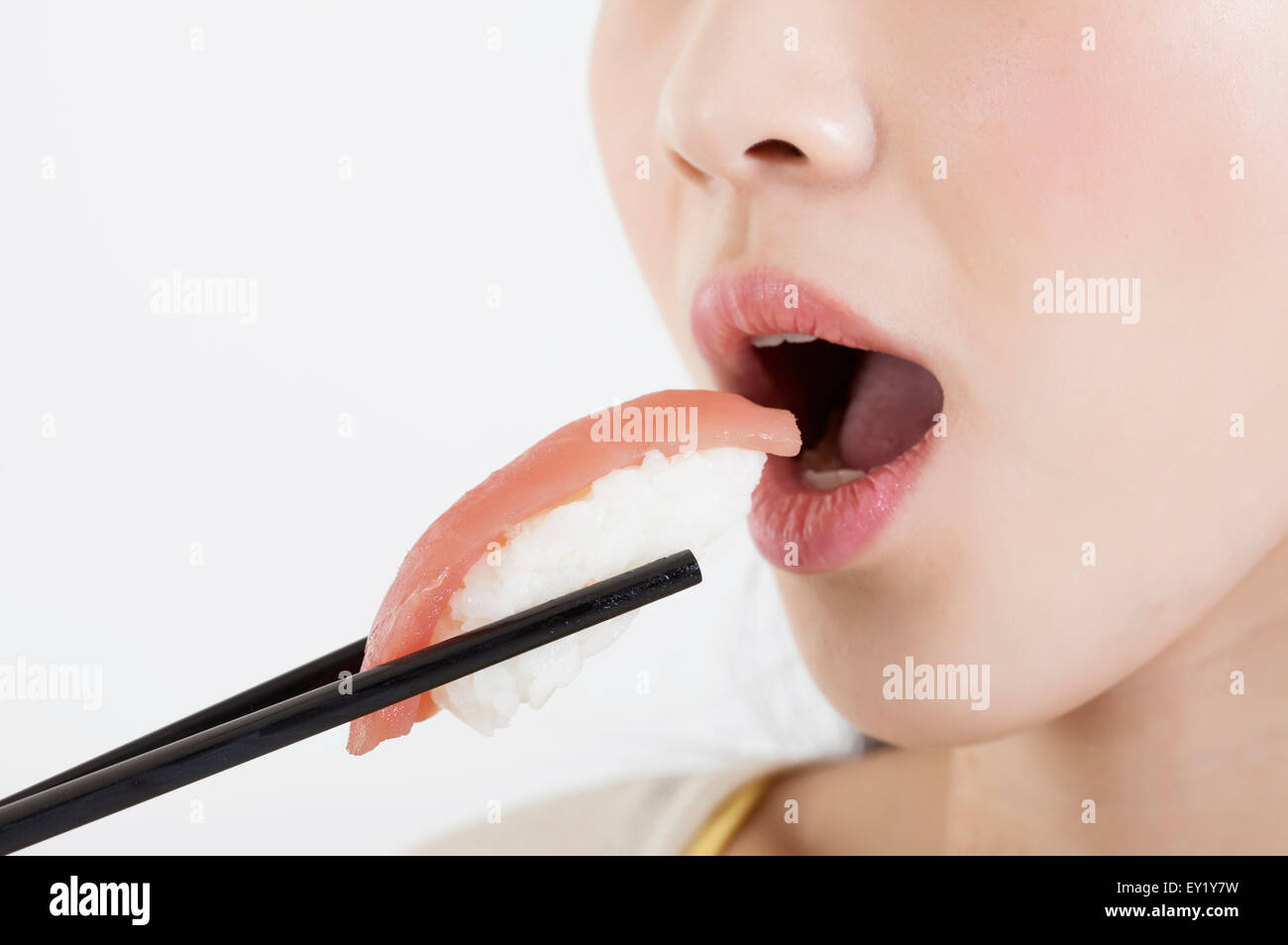 Young woman eating sashimis avec bouche ouverte, Banque D'Images