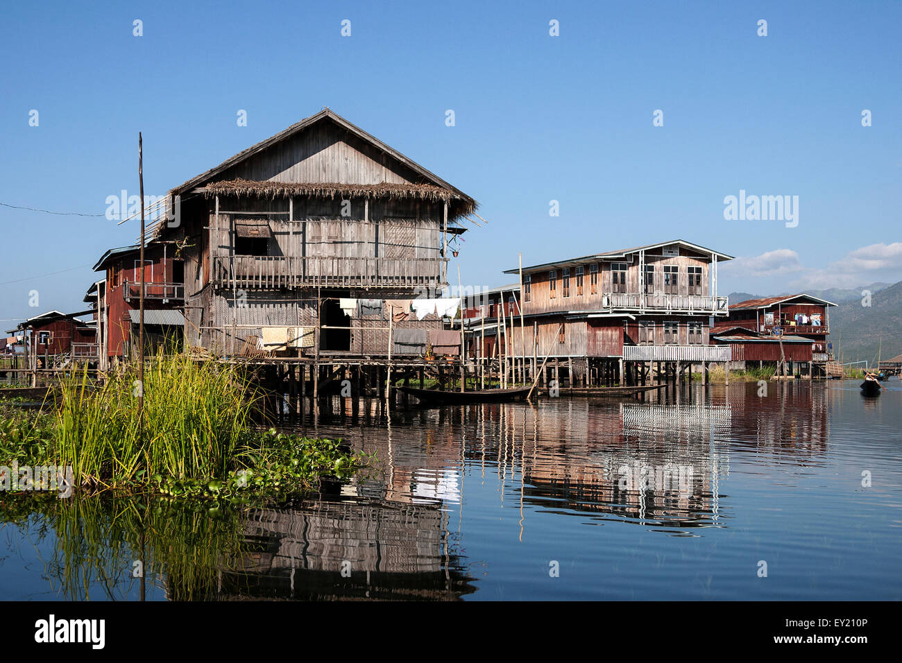 Des maisons sur pilotis traditionnelles au Lac Inle, reflet dans l'eau, l'État de Shan, Myanmar Banque D'Images