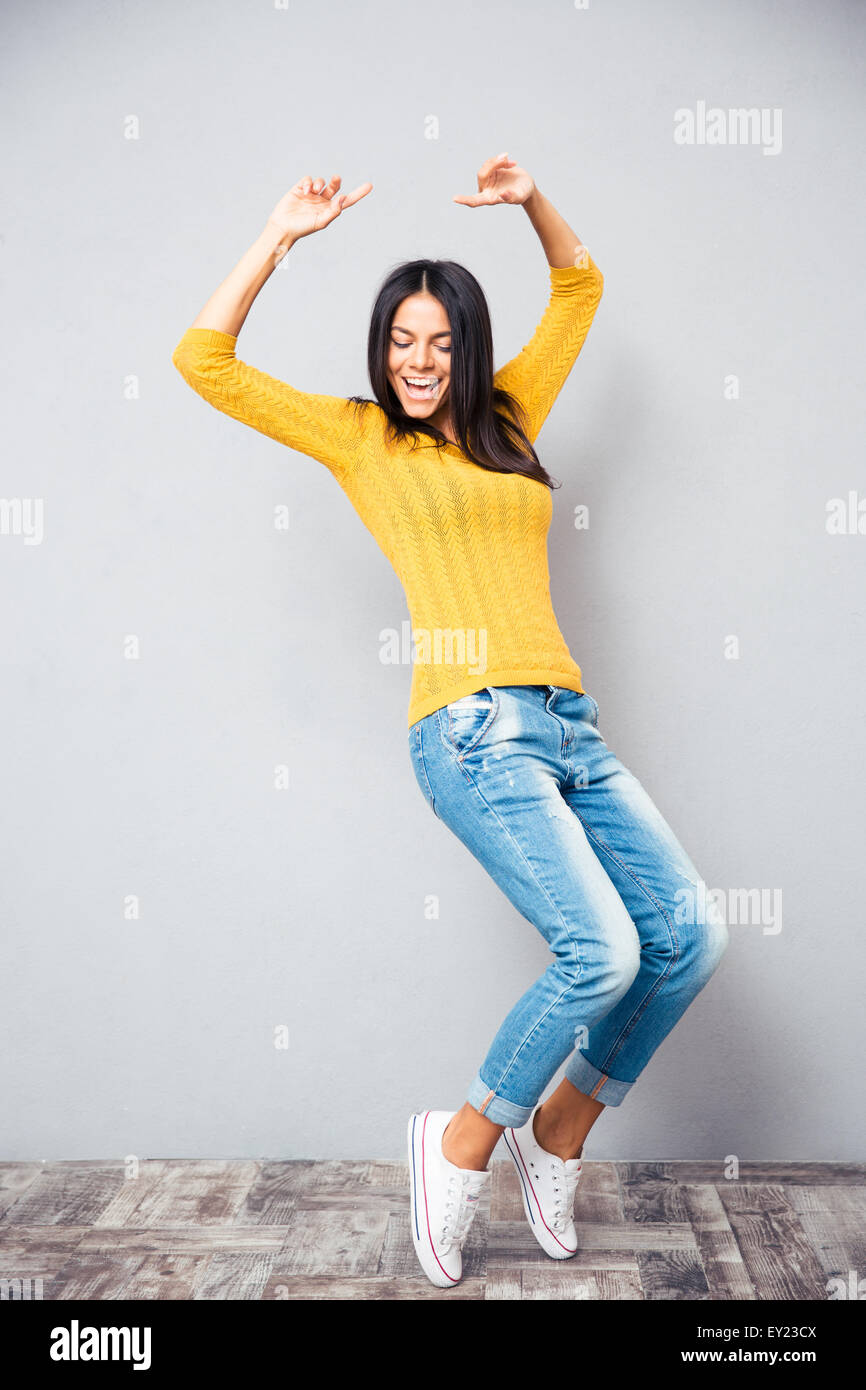 Portrait of a young woman dancing sur fond gris Banque D'Images