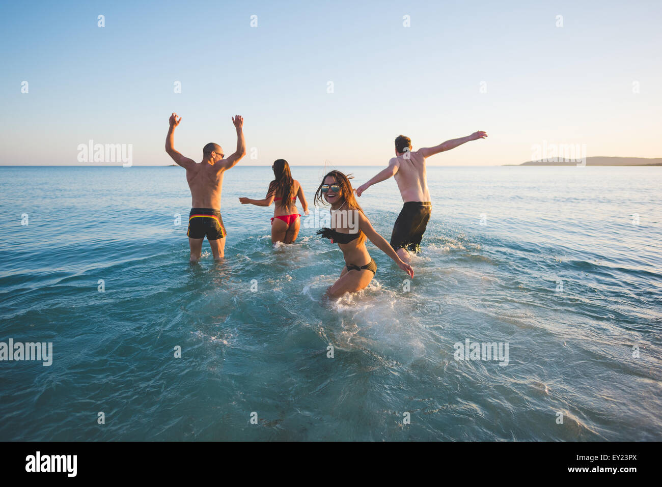 Groupe de jeunes amis multiethnique les femmes et les hommes à la plage en été, prendre un bain