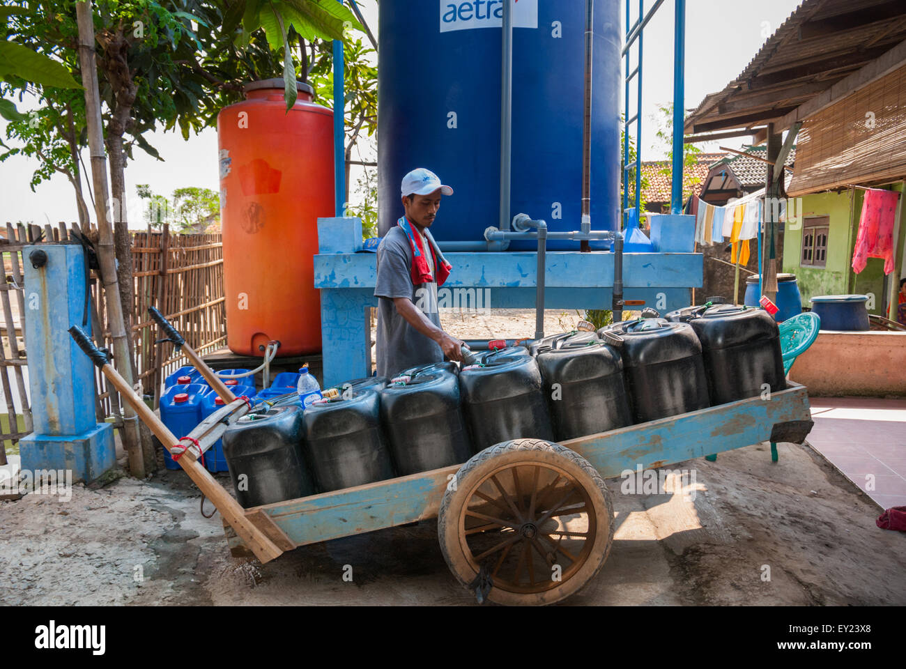 Un vendeur d'eau mobile remplit ses jerricans à une station de remplissage d'eau à Rorotan, Cilincing, dans le nord de Jakarta, Jakarta, Indonésie. Banque D'Images