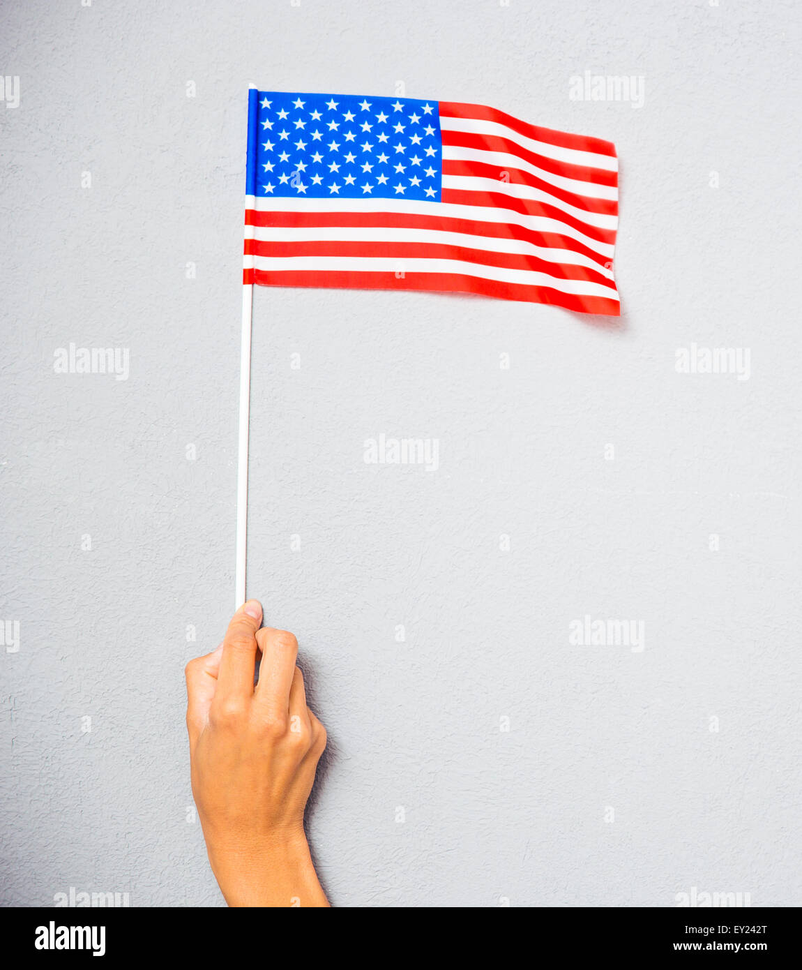 Closeup portrait of a hand holding drapeau américain sur fond gris Banque D'Images