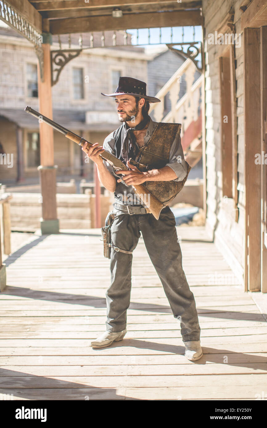 Portrait of cowboy holding up fusil sur wild west de cinéma, Fort Bravo, Tabernas, Almeria, Espagne Banque D'Images