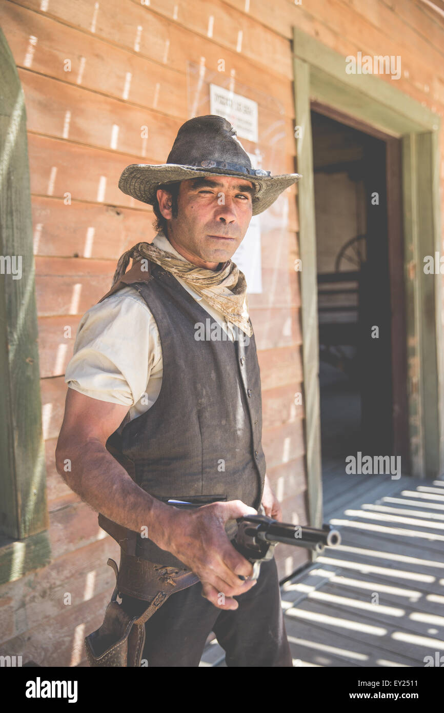 Portrait of cowboy holding up handgun on wild west de cinéma, Fort Bravo, Tabernas, Almeria, Espagne Banque D'Images